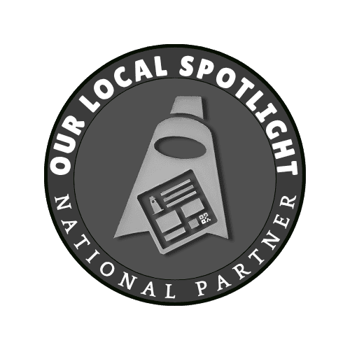 Circular badge with the text "Our Local Spotlight National Partner" surrounding a graphic of a spotlight shining on a board with documents or charts.